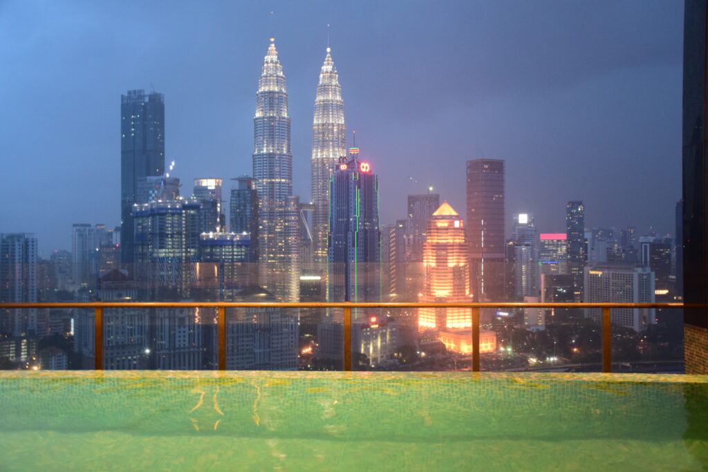 view of Petronas Twin Towers at night from pool