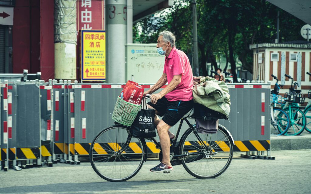old man riding bicycle in Asia