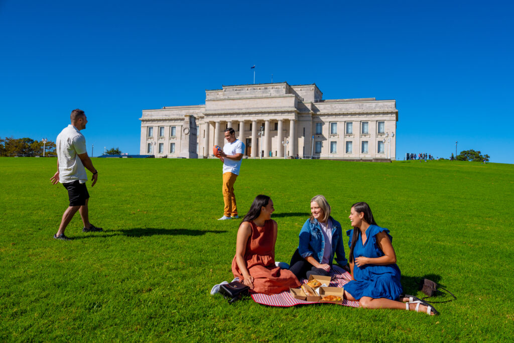group relaxing on grass in Auckland