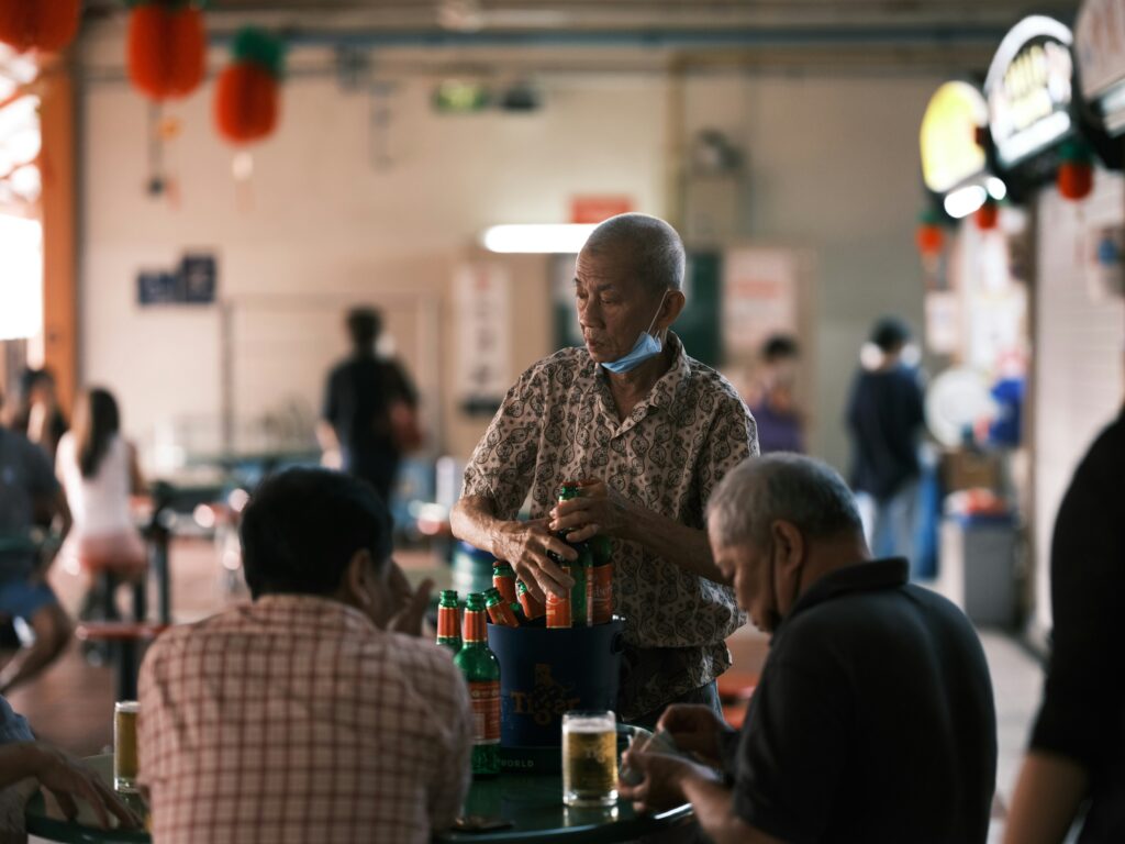 man with beer at Singapore hawker centre