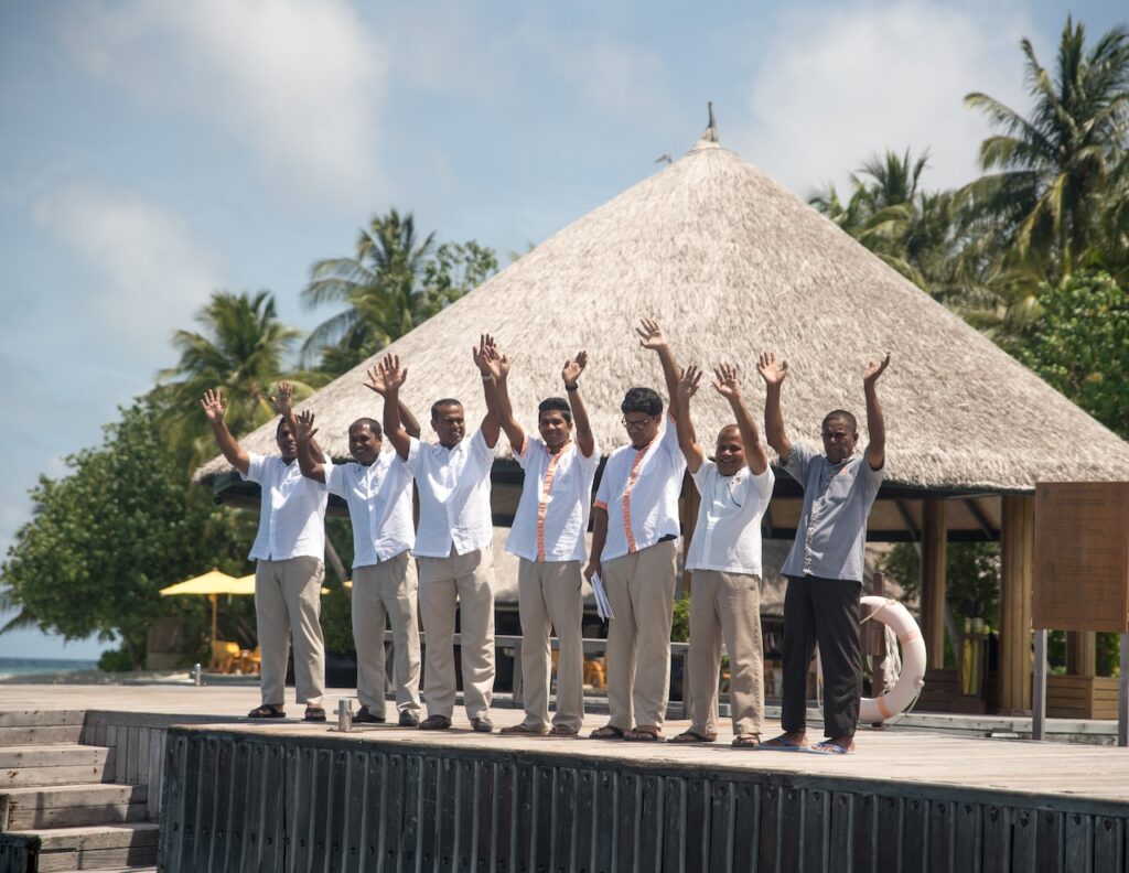 Maldives resort staff waving at seaplane