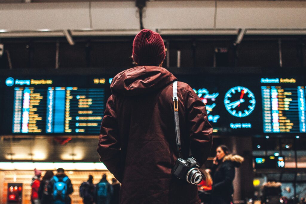 man staring at flights board at airport